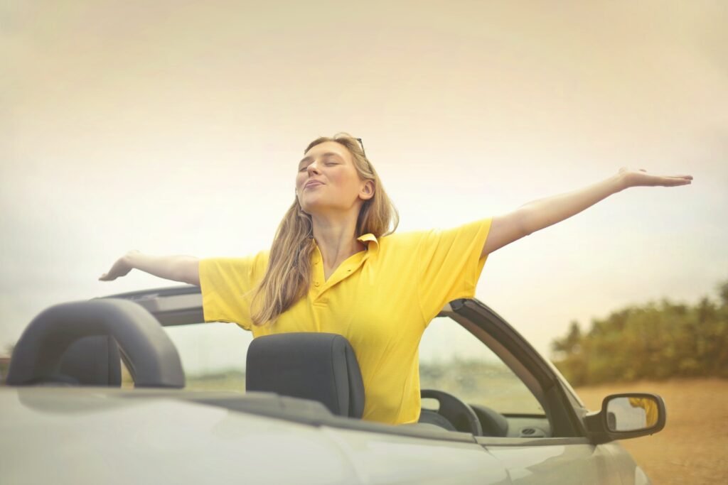 Woman Sitting on Car Under Gray Sky