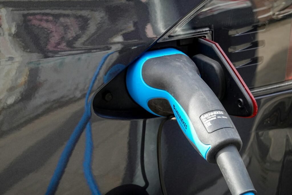 Close-up of an electric vehicle being charged using a Mennekes EV connector.
