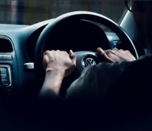 Focused view of hands on Volkswagen steering wheel, capturing driving experience.