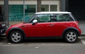 a small red car parked in a parking space