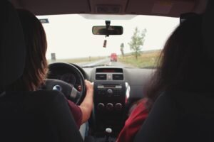 Two adults traveling by car on a scenic road near Iași, Romania.
